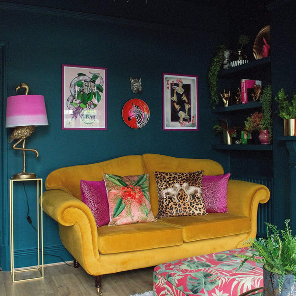  A room with a yellow sofa, colorful cushions, a flamingo lamp, wall art, and plants