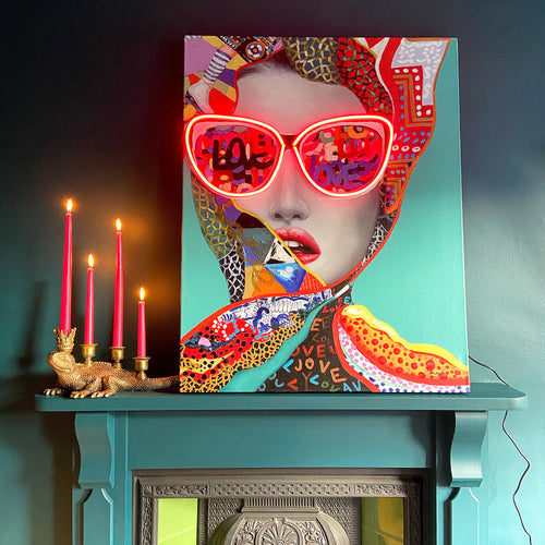 A colourful LED neon canvas artwork next to a gold candelabra holding four pink candles