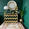 A round wall mirror and a console table with various decorative items including a gold shell planter