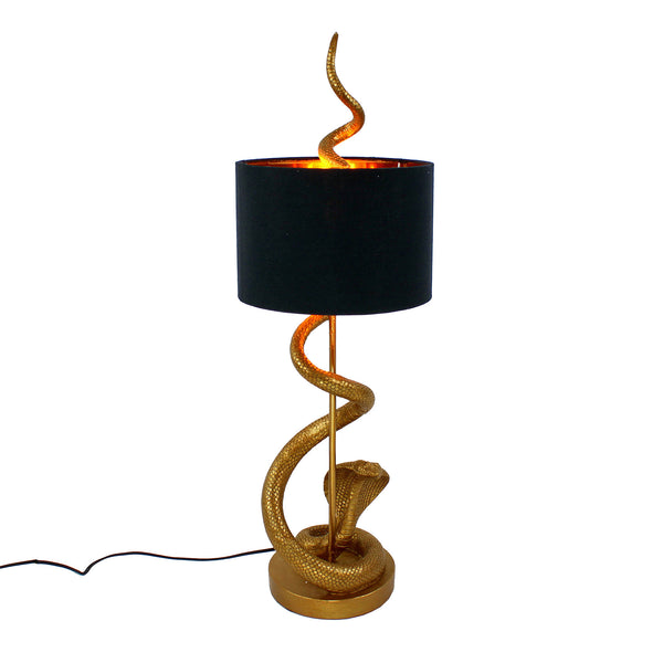 A sleek gold snake table lamp with a black shade on a white background
