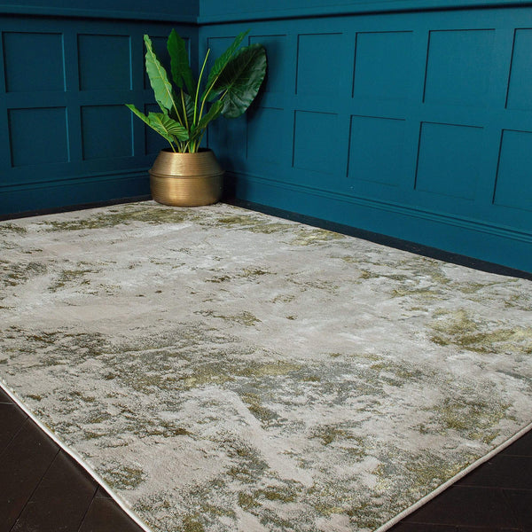 A golden lustre rug is placed on a dark wooden floor with a plant pot in the corner