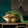 A golden lips planter on a table with a green plant