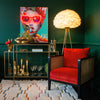 A red chair next to a console table with various decorative items including a gold lips planter