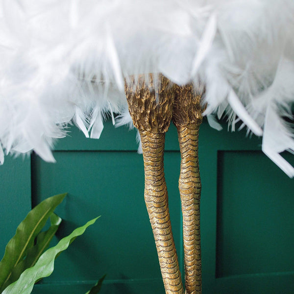 Close-up of a white feather bird leg lamp