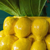 Close-up of a lemon yellow vase with plants inside it