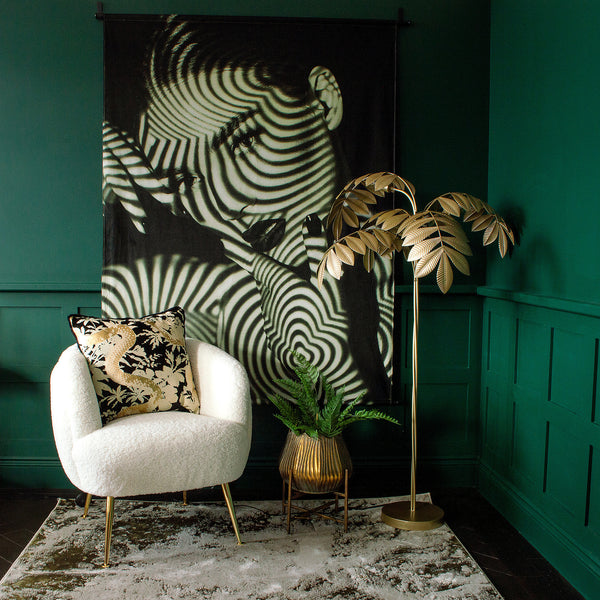  A room with a large wall hanging print, a white armchair, and a floor lamp on a rug
